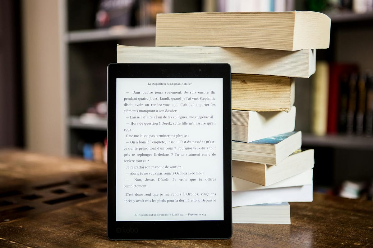 eBook reader in front of a stack of books