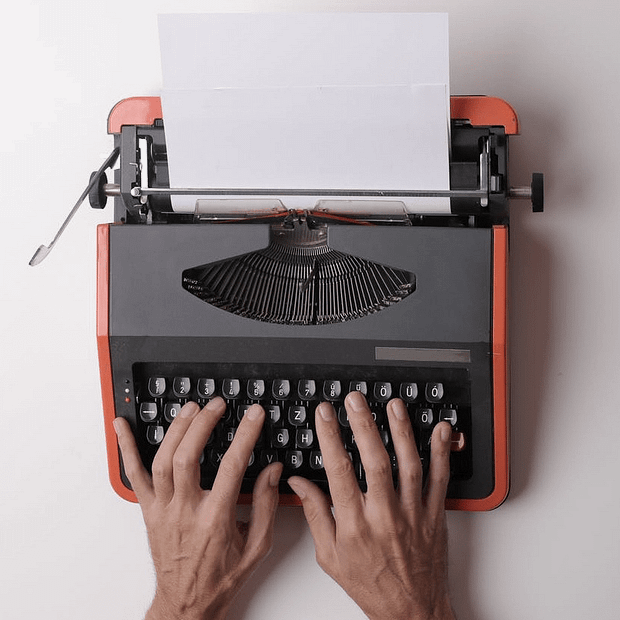 two hands on a modern retro typewriter