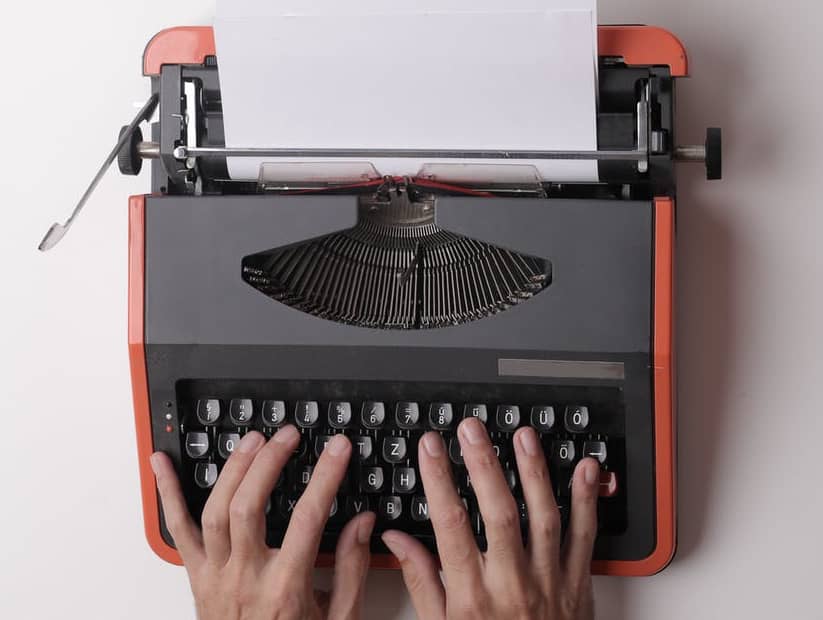 two hands on a modern retro typewriter